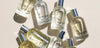 An overhead shot of eight perfume bottles made by the brand Rosie Jane