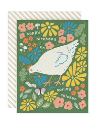 Amy Heitman's "Spring Chicken 2.0" card features a white chicken with flowers, mushrooms, a butterfly, and a worm. The blank card says "happy birthday to a spring chicken" on the front and comes with a matching envelope.