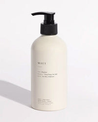 Maui Liquid Hand + Body Wash by Brooklyn Candle Studio comes in a white pump bottle. Made with organic ingredients, it features scent notes of bergamot, ylang ylang, sea salt, sea moss, and driftwood against a light background.
