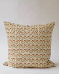 The Neelima Linen Pillow - 22 x 22 by Soil to Studio features a geometric beige, light brown, and white pattern with diamond and heart motifs, displayed against a simple light background.