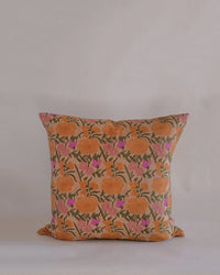 The Nargis Linen Pillow by Soil to Studio (18 x 18 in, Old Rose) features a vibrant orange floral hand block print with green stems and pink accents on beige, inspired by the Valley of Flowers—perfect for elevating any linen pillowcase collection.