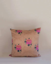 The Babita Linen Pillow - 18 x 18 in Old Rose by Soil to Studio features a square beige cover adorned with pink and yellow floral motifs inspired by the Valley of Flowers, shown against a plain light background.