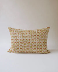 The Neelima Linen Pillow (14 x 20) by Soil to Studio features a beige background with a geometric pattern in brown, rust, and cream, from The Thar Edit, and is shown against a plain light-colored surface.