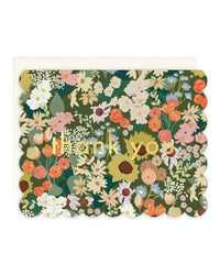 The Amy Heitman Flower Market Scallop single card features a colorful floral design, gold "thank you" lettering, and scalloped edges. An ivory envelope is partially visible behind this elegant blank-interior card.