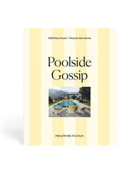 Piecework Puzzles' Poolside Gossip - Slim Aarons Collab 1000 Piece Puzzle comes in a yellow-and-white striped box, featuring iconic women by a pool with mountains behind, evoking classic midcentury style.