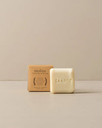 A moisturizing Saarde Olive Oil Bar Soap in Medina is embossed with the brand’s name and placed in front of a brown box labeled medina natural olive oil bar soap.