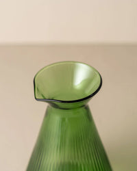 Close-up of the top of the Saarde Kairos Angular Carafe in Green, showing its vertical ribbed texture and small spout against a smooth beige background.