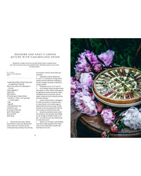 A round herb-garnished quiche sits on a wooden surface with pink peonies, alongside a Nordic rhubarb and goat’s cheese quiche recipe from Cozy Publishing’s Nordic Summer Cookbook.