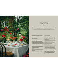 A midsummer table with a white cloth, plates, glasses, flowers, and crayfish dishes under trees. On the right: “How to Host a Crayfish Party” instructions from the Nordic Summer Cookbook by Cozy Publishing.
