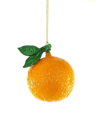 The Cody Foster Round Orchard Orange Ornament features hand-crafted glass with textured skin and glittery green leaves, hanging from a gold string. Add whimsical charm to your Christmas décor with this unique holiday accent.