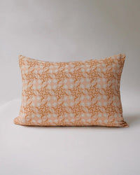 The Khushi Linen Pillow by Soil to Studio measures 14 x 20 inches and features a pastel pink background with a white floral pattern, shown against a plain light backdrop.