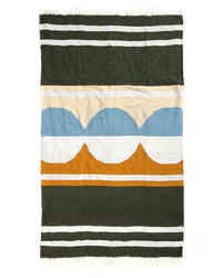 The Luna Lago - Blanket Roll by caminito is a woven, lightweight blanket featuring black, white, tan, yellow, and blue stripes with abstract blue and orange arches at the center and fringed short edges—ideal for outdoor use.