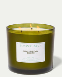 The Tomato XL Candle by Flamingo Estate is a green glass jar candle made with vegetable wax, featuring three flames and shown burning against a white background.