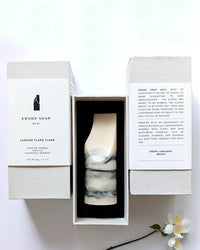 A marble-patterned bar of handmade soap by Ume Studio, the Erode Soap Mini in Jasmine Ylang Ylang, comes boxed with product details and a description printed on the inside flaps.