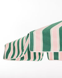 A close-up of the Business & Pleasure Co Amalfi Umbrella - Bistro Green Stripe, featuring green, pink, and white vertical stripes, stylishly provides UV protection against a plain white background.