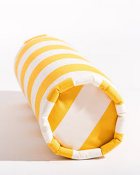The Crew Mimosa Yellow Stripe Bolster Pillow by Business & Pleasure Co features alternating yellow and white stripes, pictured on its side against a white background. Ideal for versatile indoor or outdoor comfort and style.