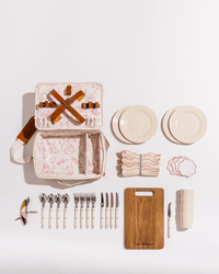 The Business & Pleasure Co Picnic Set - Laurens Pink Stripe features plates, cups, cutlery, cutting board, corkscrew, napkins, and a pink-striped carrying case—the perfect premium companion for your next outdoor picnic.