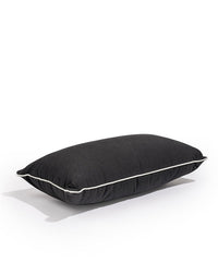 The Rectangle Throw Pillow - Rivie Black by Business & Pleasure Co, crafted from durable Pleasuretex® fabric with white piping, rests on a plain white background.