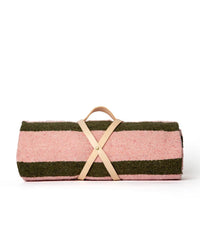 The caminito Marea Fresca - Blanket Roll features pink and green stripes, is handwoven, and comes rolled up with a light tan leather strap and handle, displayed on a plain white background.