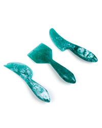 The Casa Amarosa Resin Cheese Knife Set of 3 in Green features uniquely shaped, marbled handles, making this handmade set a stylish and practical addition to your next charcuterie board.