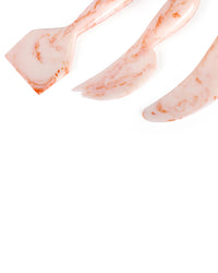The Casa Amarosa Resin Cheese Knife Set of 3 in Ivory Pink features a spatula, cheese knife, and spreader, stylishly arranged on a white background.
