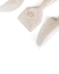 Casa Amarosa’s Resin Cheese Knife Set of 3 in Vanilla features light-toned utensils—a spatula, scraper, and spreader—perfect for charcuterie boards, beautifully arranged on a white background.
