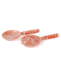 The Casa Amarosa Resin Short Salad Server Set in Pink includes a spoon and fork with textured handles, beautifully displayed on a white background.
