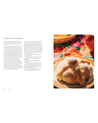 An overhead view shows Pan de Muerto on a plate beside a recipe page from Mamacita, Andrea Pons’ Mexican cookbook from Chronicle Books, all set against a colorful background.