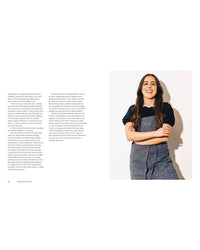 A woman with long brown hair, wearing a gray apron and black shirt, stands smiling with folded arms beside a page from Mamacita, the cherished family recipes cookbook by Chronicle Books.