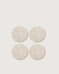 The graf lantz Bierfilzl Merino Wool Felt Round Coaster Solid in Heather White (4 Pack) offers an elegant, sustainable touch to your home decor with four light gray coasters arranged in a stylish square on any surface.