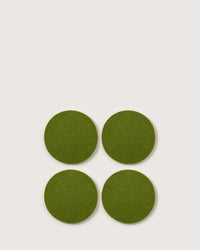 Four Bierfilzl Merino Wool Felt Round Coasters in Loden Green by graf lantz are arranged in a square on a plain, light background.
