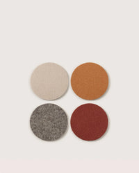 The graf lantz Bierfilzl Merino Wool Round Coaster Multi in Mesa 4-Pack features beige, orange, gray, and red coasters made from premium German Merino wool—a sustainable home décor choice.