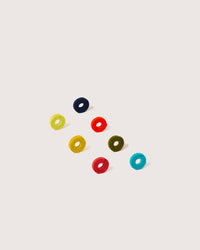 Eight colorful, round graf lantz Cheers Wine-Otes Merino Wool Felt Wine Marker Note Card charms are arranged in two diagonal lines on a plain, light background. Each marker is a different color.