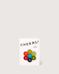 The graf lantz Cheers Wine-Otes Merino Wool Felt Wine Marker Note Card stands upright, showcasing CHEERS! above seven colorful wool felt circles and a small tree branch illustration.