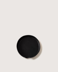 The graf lantz Kobon Leather Round Tray in Black sits on a light surface—perfect as a sustainable organizer for your essentials.