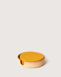 The Kobon Leather Round Tray in Natural by graf lantz is a stylish, round organizer perfect for holding coasters or small items, adding both function and elegance to your space.