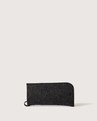 The graf lantz Merino Wool Felt Anzen Eyeglass Sleeve in Charcoal is a rectangular accessory with a rounded corner and small loop, displayed on a light background, offering stylish protection for your eyewear.