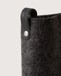 Close-up of the graf lantz Merino Wool Felt Anzen Eyeglass Sleeve in Charcoal, with a black leather loop and metal rivet, offering stylish protection for your eyewear against a plain background.