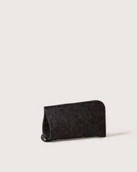 The graf lantz Merino Wool Felt Anzen Eyeglass Sleeve in Charcoal, featuring a rounded top and open side, stands upright on a plain light background, offering stylish protection for your eyewear.