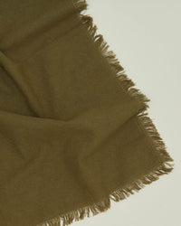 A close-up of the Essential Dinner Napkins in Olive by Hawkins New York, featuring fringed edges and laid flat on a light surface. Set of 4.