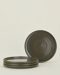 A set of four olive-colored Essential Dinner Plates by Hawkins New York, shown with three stacked and one standing upright against a light background. Stylish and dishwasher safe, perfect for everyday use.
