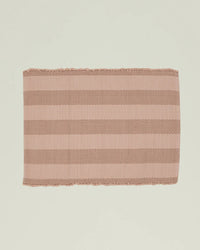 The Essential Floor Mat in Blush by Hawkins New York is a rectangular, ribbed mat with wide light pink and brown stripes, crafted from recycled fibers.