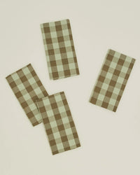 The Hawkins New York Essential Gingham Dinner Napkins in Sage/Olive come as a set of four rectangular cotton napkins, featuring a classic check pattern—ideal for any dinner occasion.