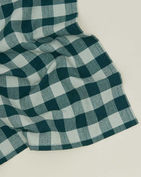 A set of Hawkins New York Essential Gingham Dinner Napkins in Sky/Peacock, featuring a green and white checkered pattern, is displayed flat against a light background.