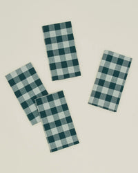 The Essential Gingham Dinner Napkins in Sky/Peacock by Hawkins New York are a set of four 100% cotton napkins, each featuring a blue and white checkered pattern.