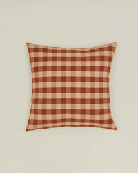 The Hawkins New York Essential Gingham Pillow, 18x18 inches in Blush/Terracotta European linen, features a red and beige check pattern and comes with a down insert for added comfort. Displayed against a plain light background.
