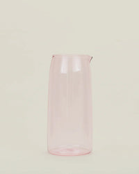 The Hawkins New York Essential Glassware - Pitcher in Blush, a translucent pink pitcher with a spout, stands upright against a plain off-white background.