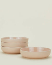 Set of pink ceramic bowls on a light beige background