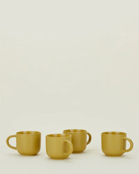 Four mustard Essential Mugs by Hawkins New York are arranged in a row on a plain light background, highlighting this vibrant set of 4.