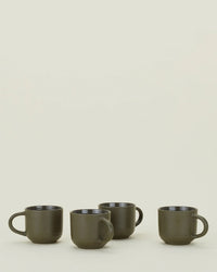 A set of four Hawkins New York Essential Mugs in Olive is lined up on a light surface with a plain off-white background.